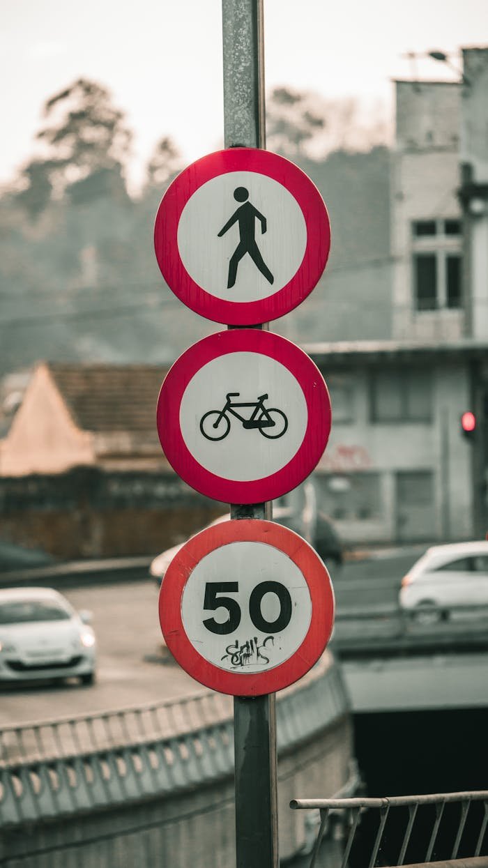 creative-02 Traffic and speed limit signs in urban Spain, featuring pedestrian, bicycle, and speed symbols.