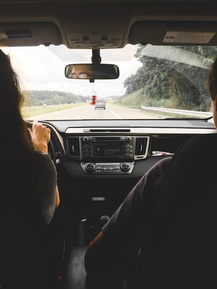pexels photo 142853 View from inside a car showing passengers looking out at an open highway, emphasizing travel and journey.