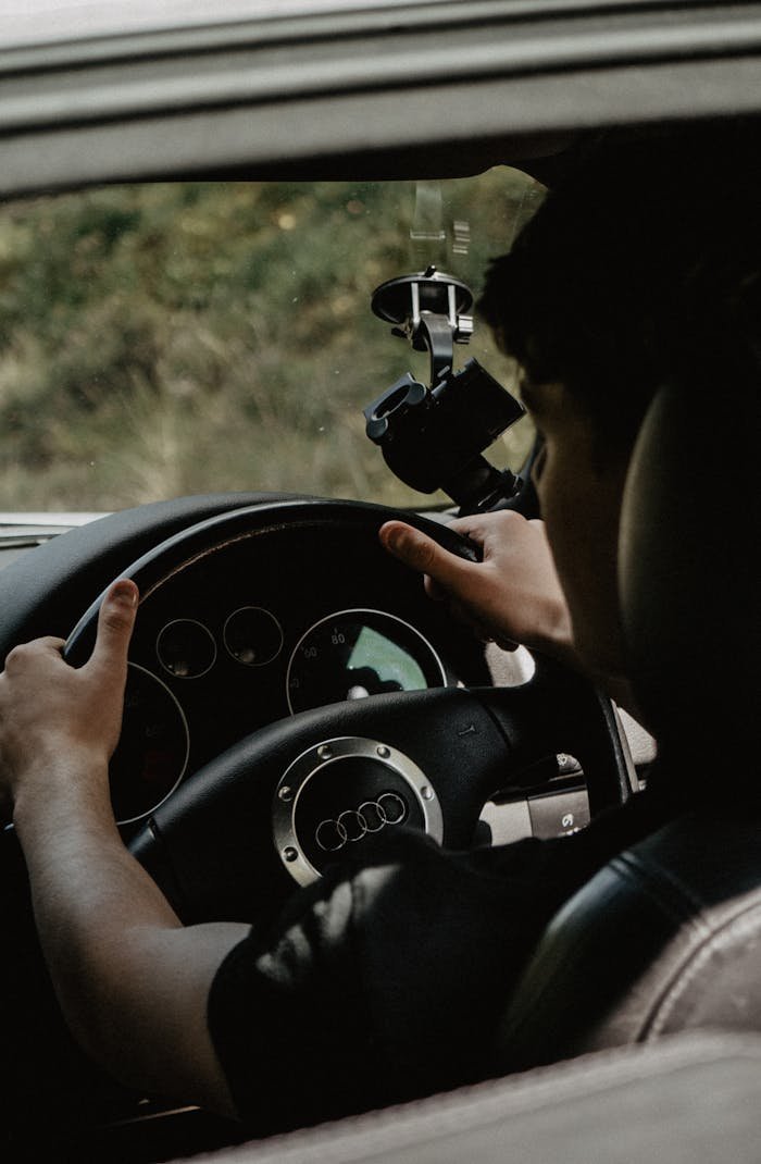 brand-01 Interior view focusing on a man steering an Audi car, showcasing a modern luxury vehicle design.