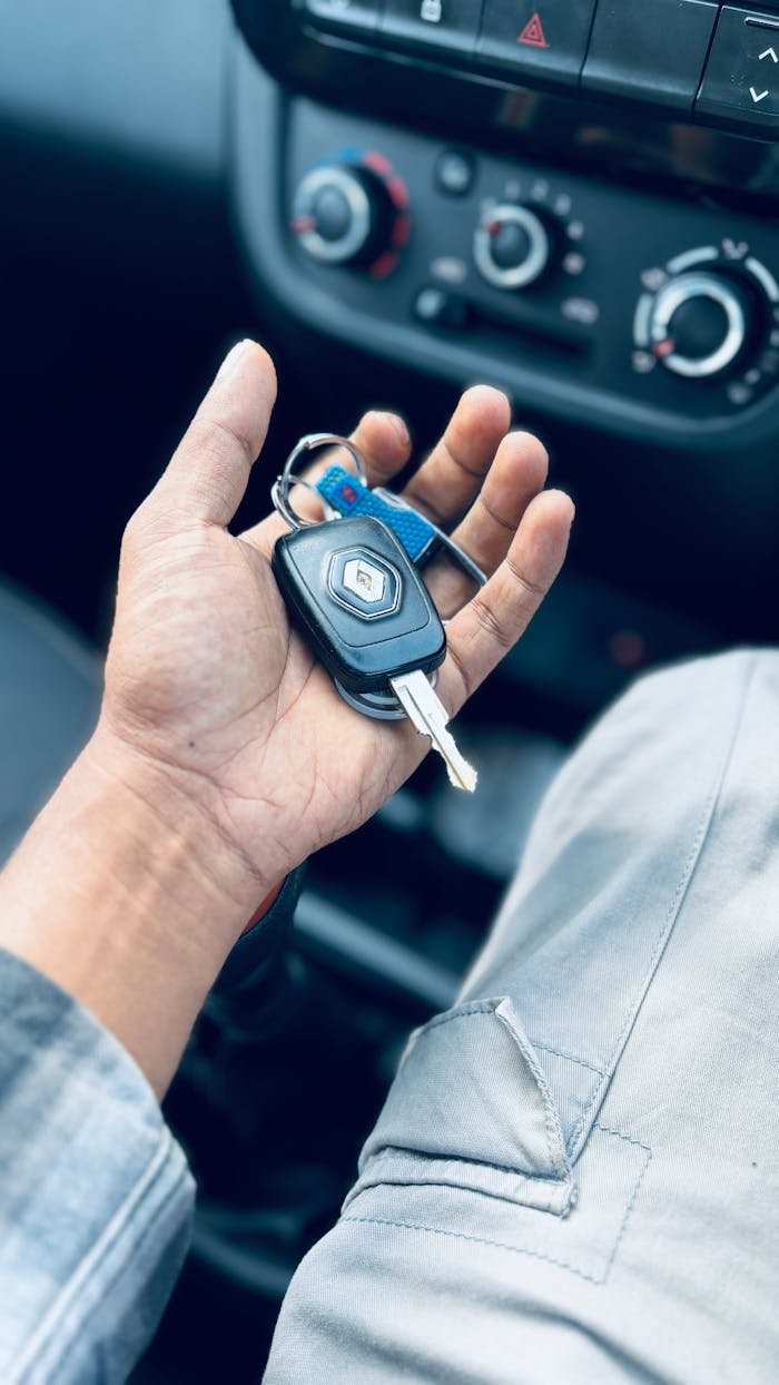 creative-03 Hand holding car keys inside a vehicle, showing dashboard details.