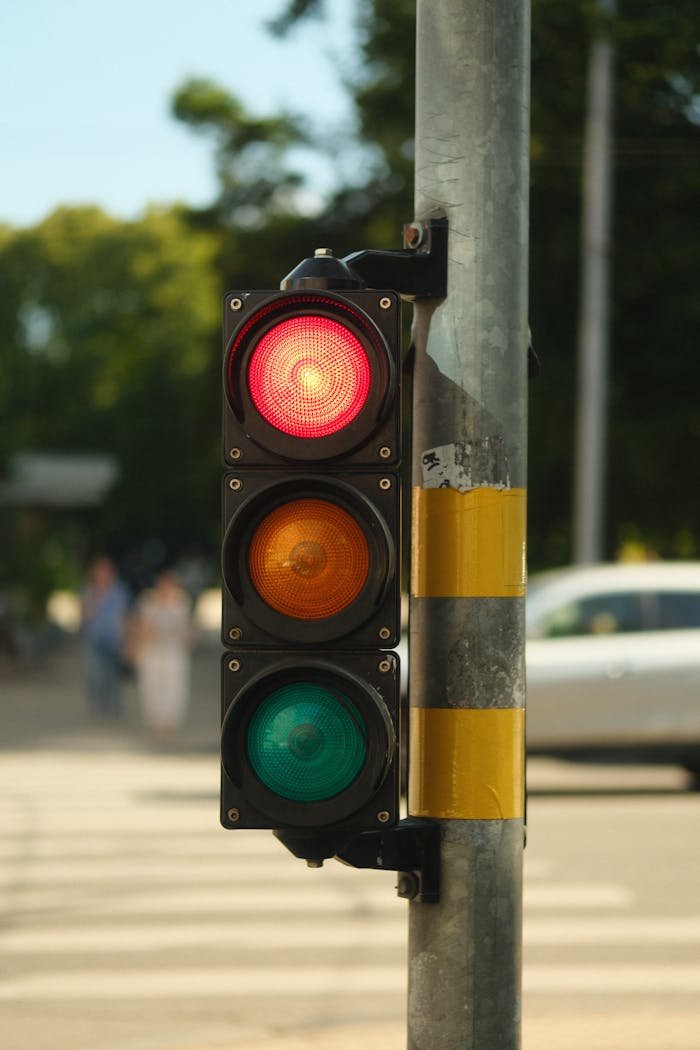 creative-03 Traffic light showing red signal on a busy street with blurred background.