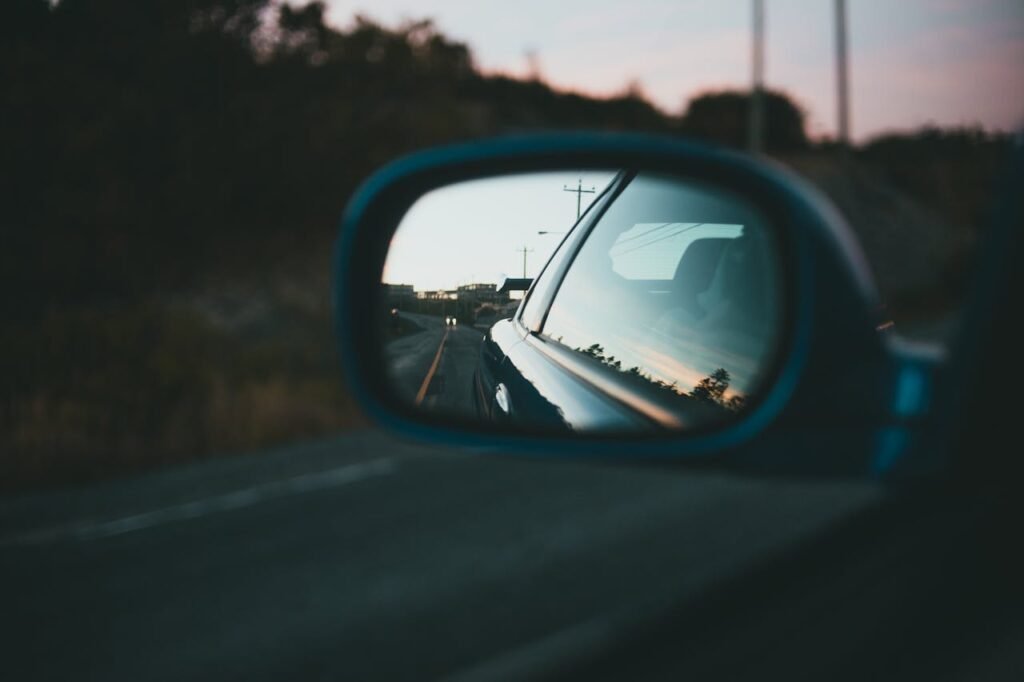 pexels photo 9661253 A tranquil road with blurred background is reflected in a car's side mirror.